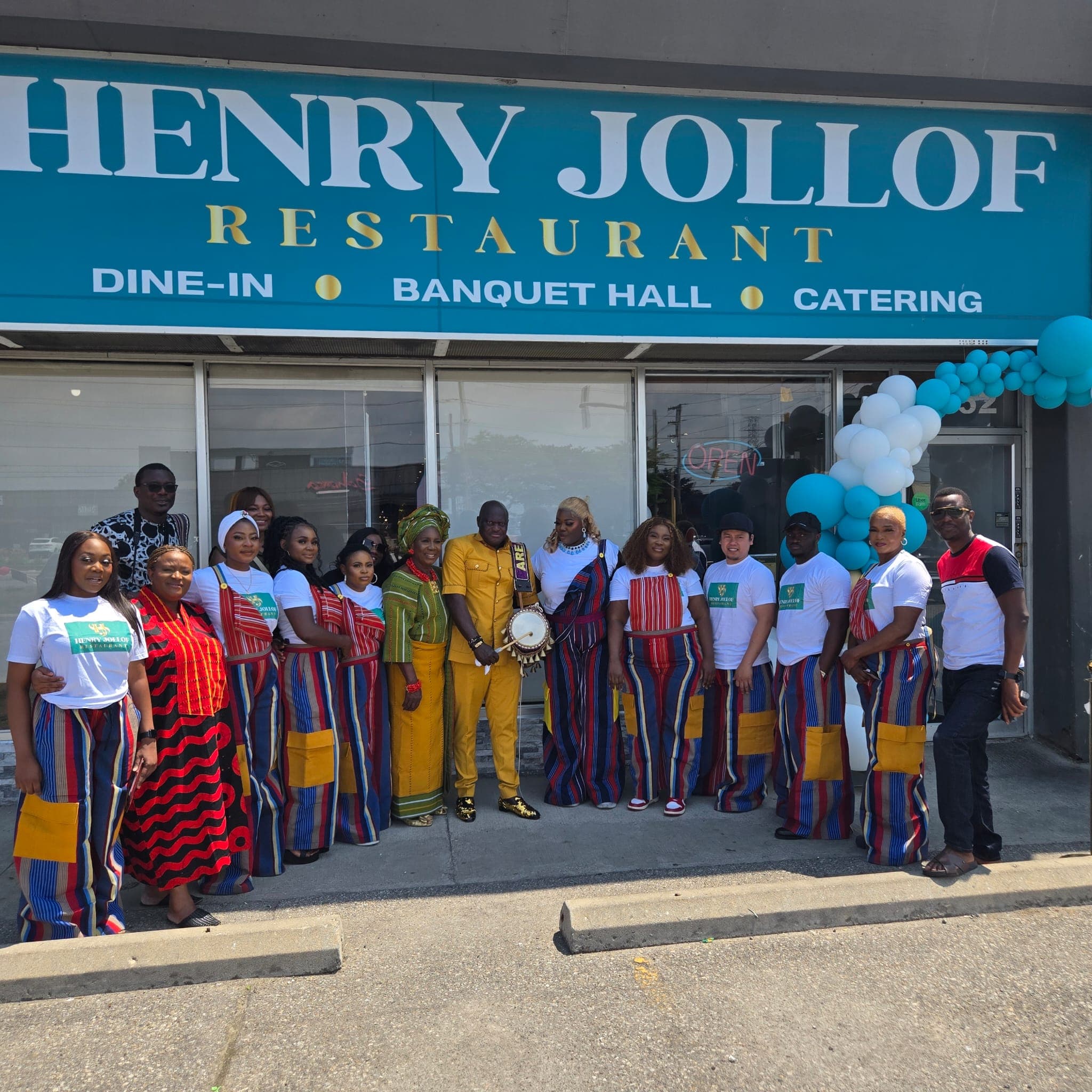 The Henry Jollof team posed in front of the restaurant at the grand opening, dressed in kente print.