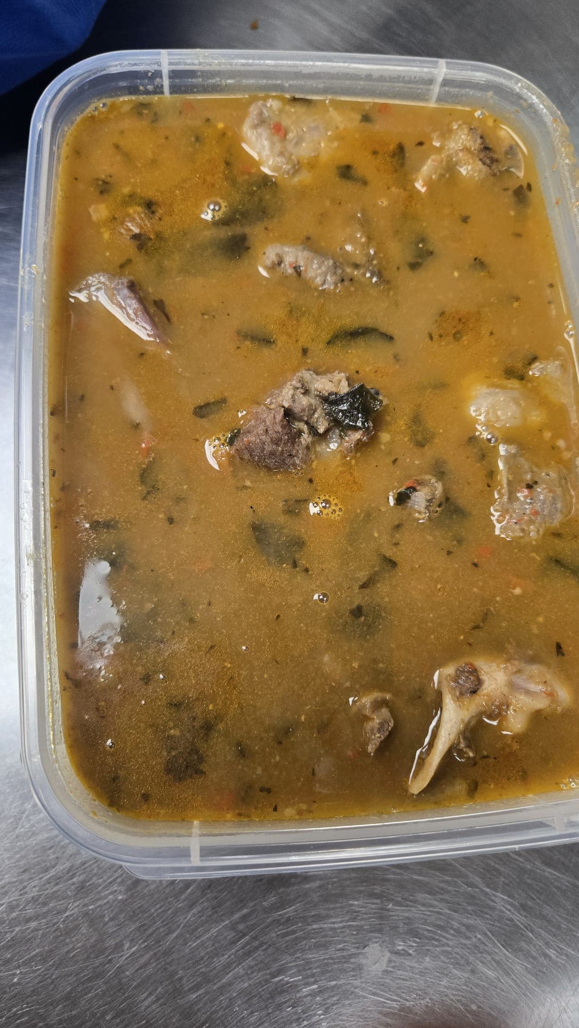 Assorted meat pepper soup with goat meat and utazi leaves in a rich broth.