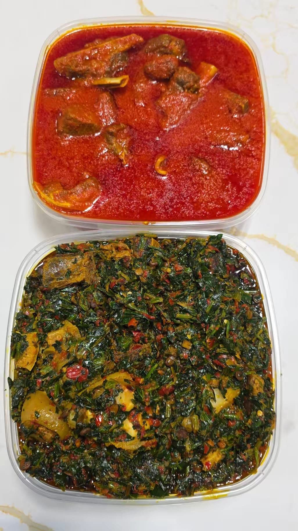 Ayamase ofada stew and efo riro packed in takeout containers.
