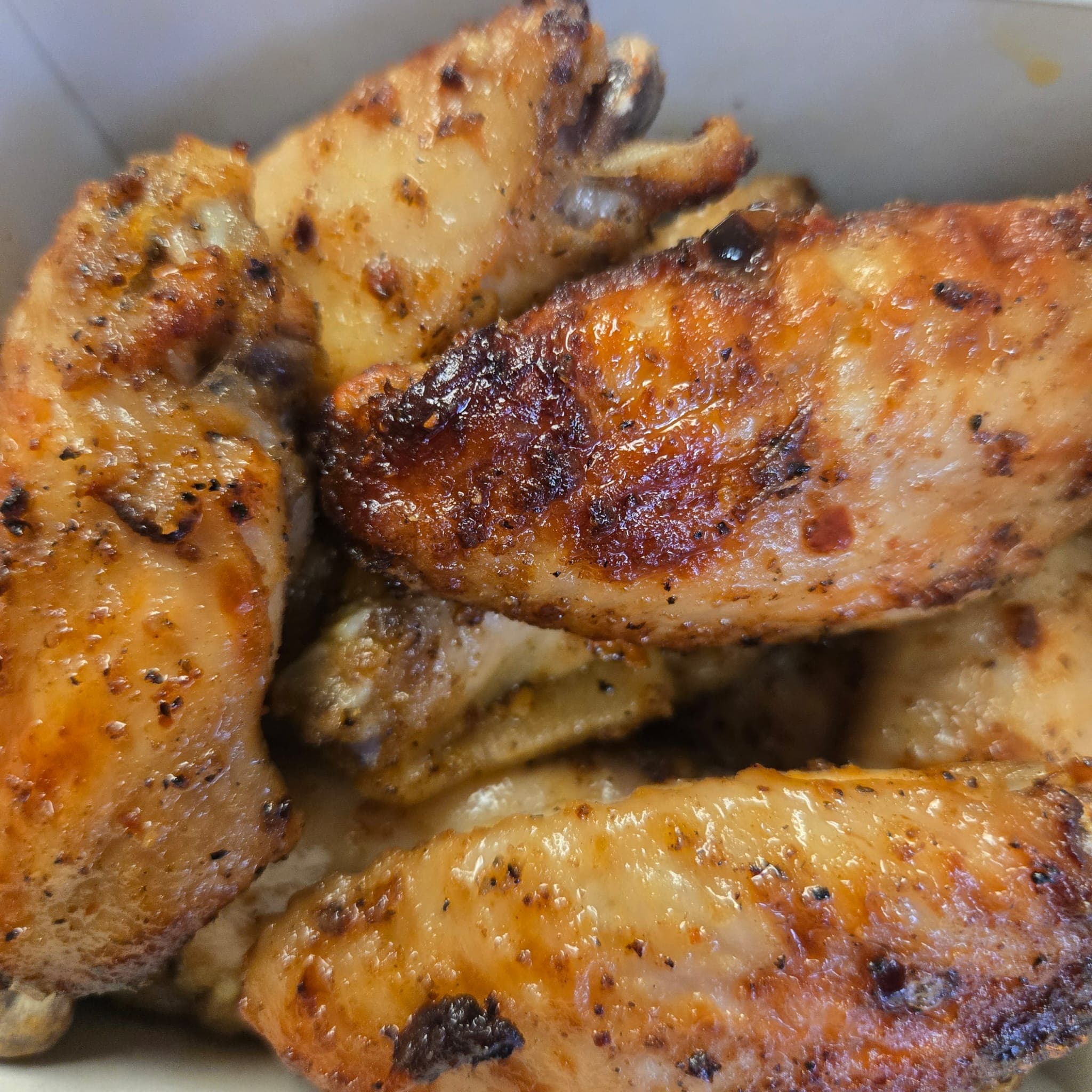 Golden grilled chicken, seasoned and charred at the edges.