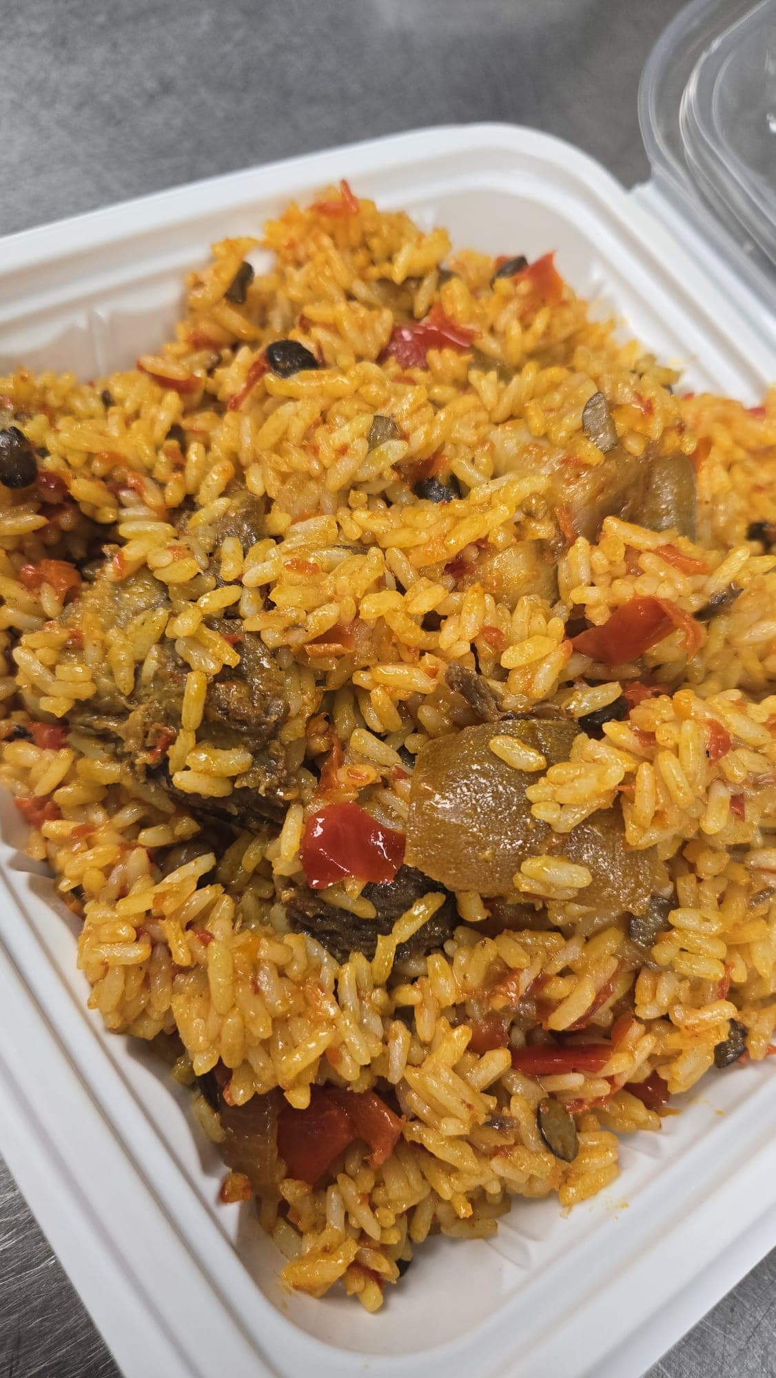 Ofada rice tossed with assorted meat, peppers and ponmo.
