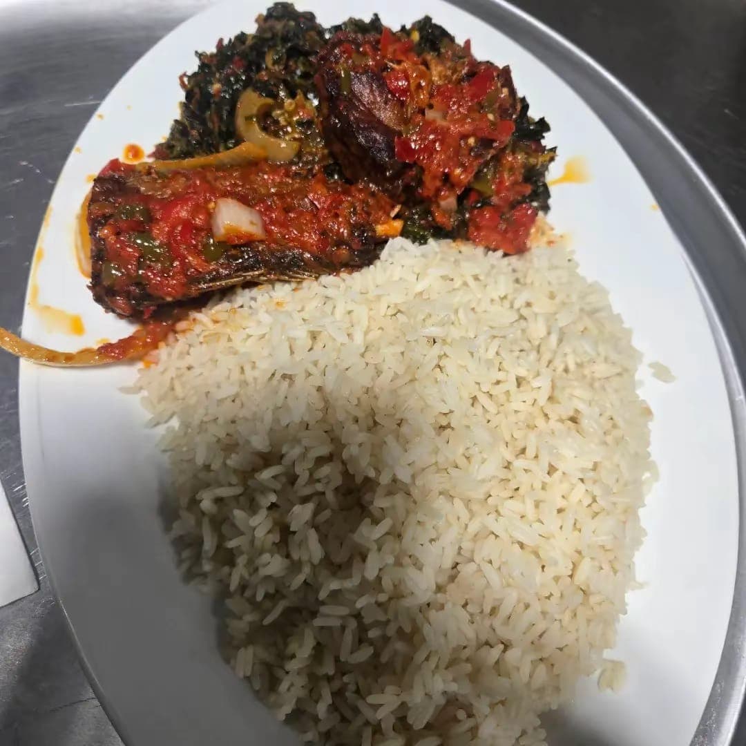 White rice served with efo riro and stewed fish in pepper sauce.